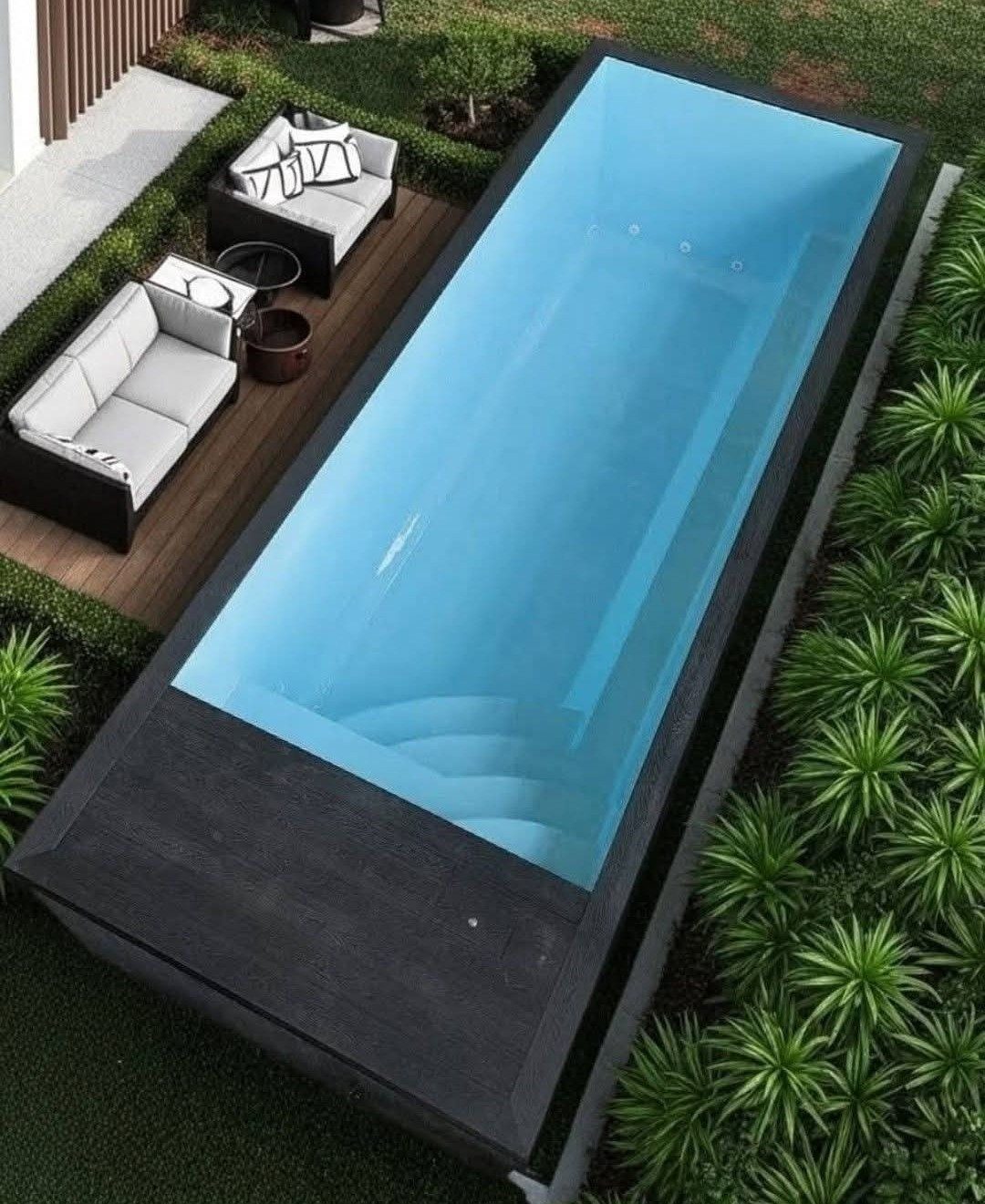Overhead of a long dark plunge pool set in planting.