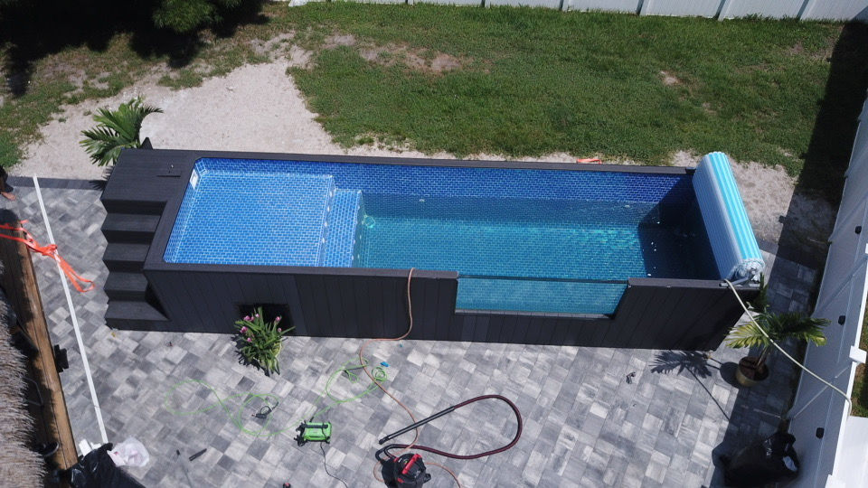 Overhead of a long dark plunge pool with the cover rolled aside.