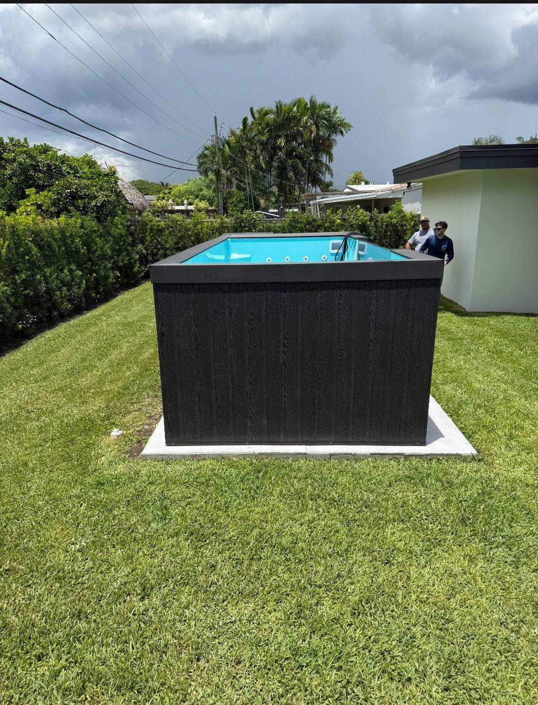 A square dark plunge pool on a small concrete pad.